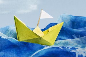 One Little Word - Yellow paper boat on a blue sea