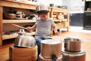 stock image of child playing the drums with pans